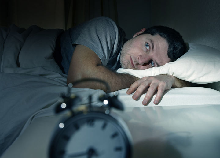 Man wide awake while laying in his bed