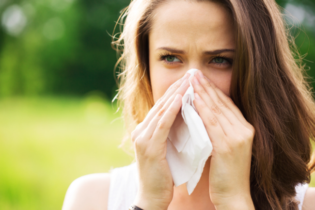 A woman in las vegas with allergies blowing her nose