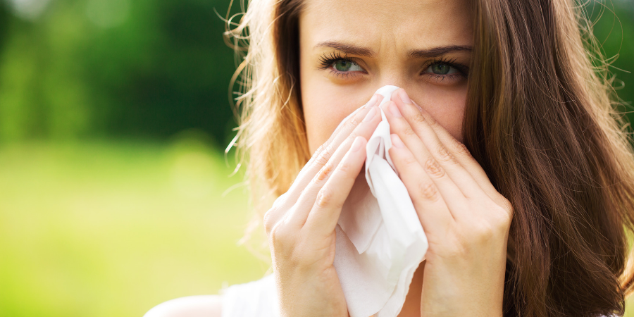 A woman in las vegas with allergies blowing her nose