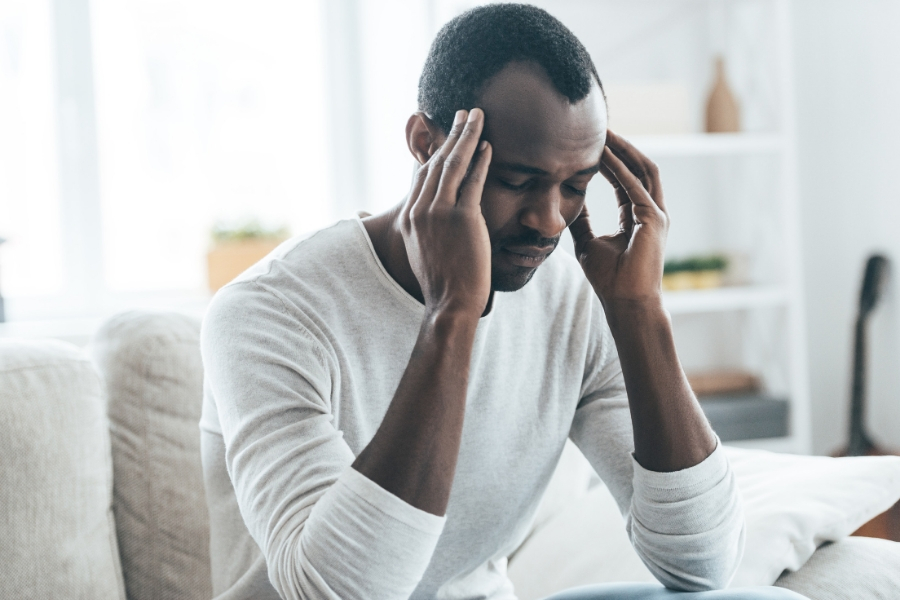 Man suffering from a sinus headache touching the sides of his head