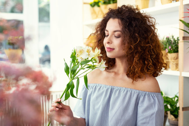 Nice young woman smelling a flower after balloon sinuplasty