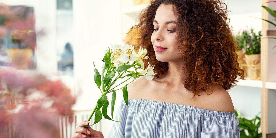 Nice young woman smelling a flower after balloon sinuplasty