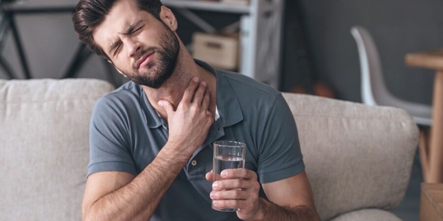 A man suffering from a sore throat and sinus pain