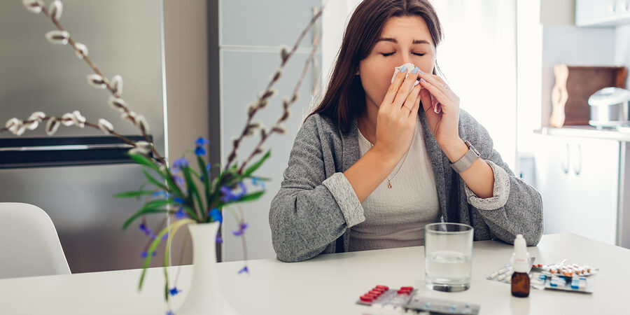 Spring Allergy. Young Woman Sneezing Because Of Flowers Surround