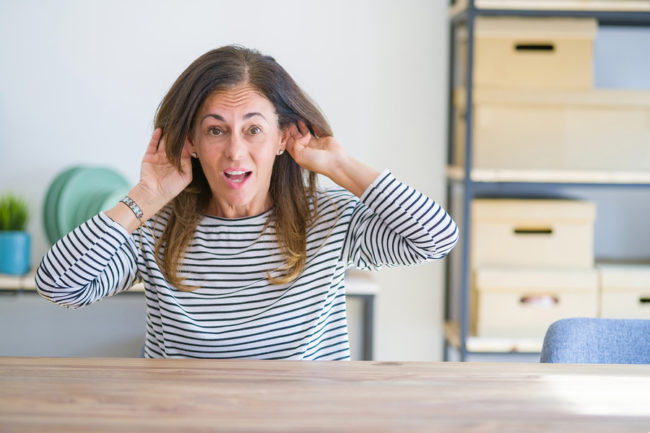 Middle age senior woman clearing her ears