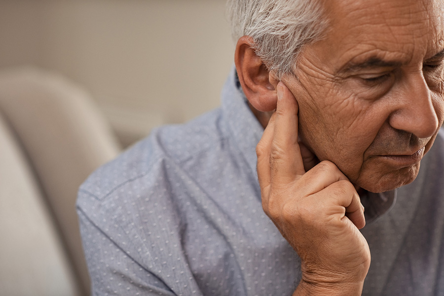 Side view of senior man clearing his ears