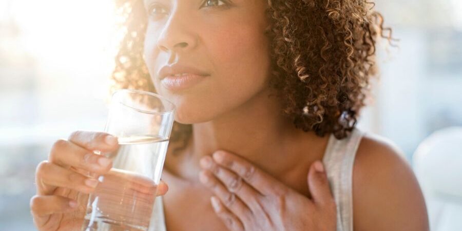 Woman drinking a glass of water mouth is dry