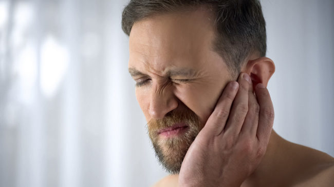 Man Holding His Aching Ears sinus problems