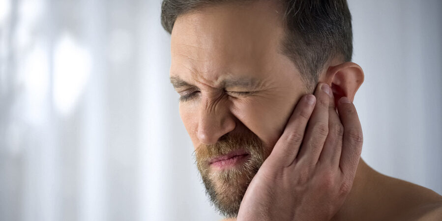 Man Holding His Aching Ears sinus problems